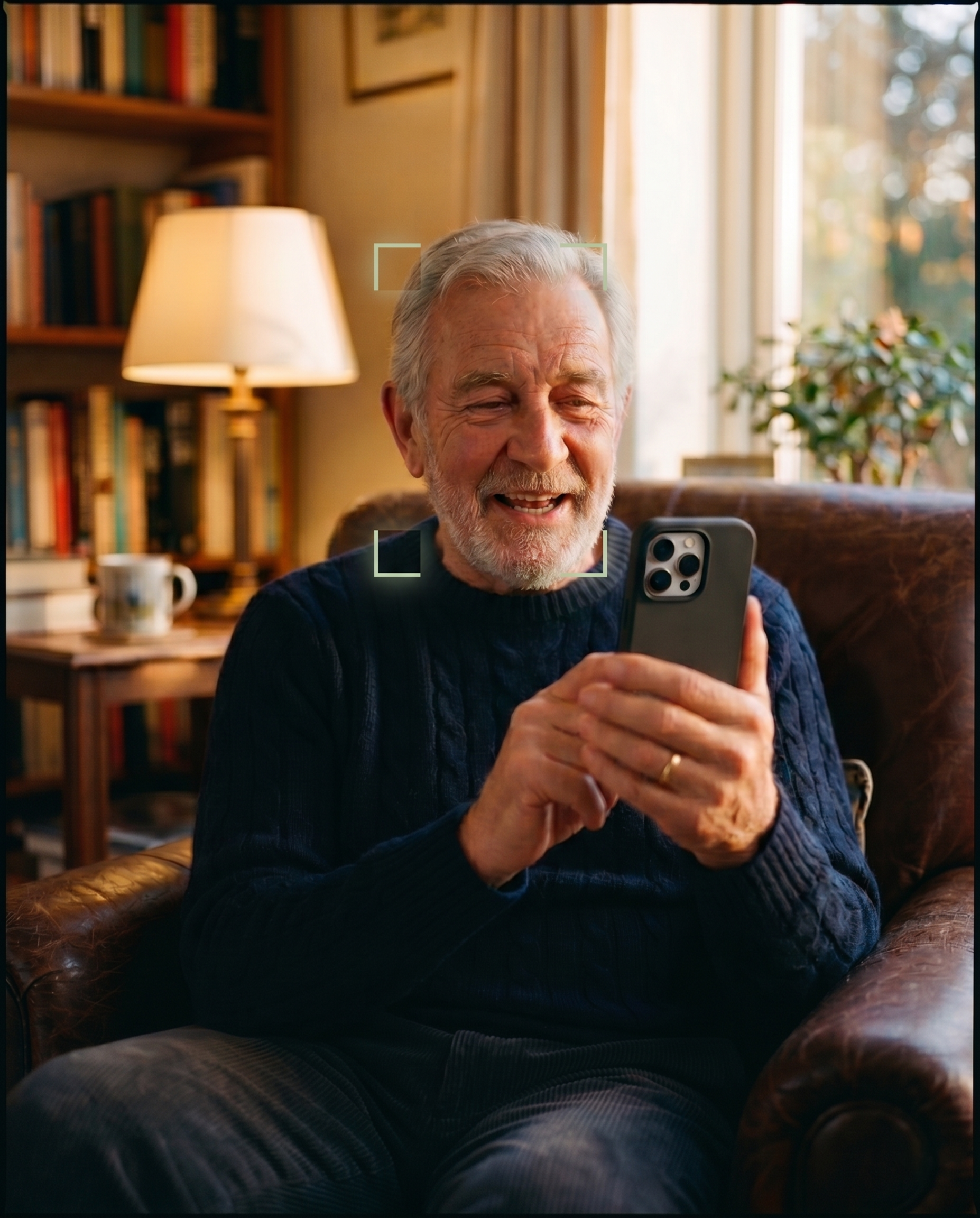 An older man sitting in a warm, book-lined living room on a video call with family. code:blue runs quietly in the background.